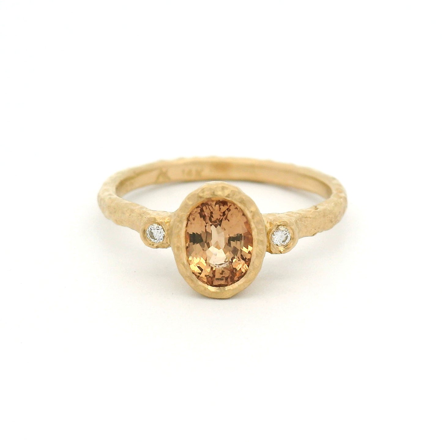 14K yellow gold organic textured engagement ring with bezel-set 1.11ct oval peach sapphire and two bezel-set natural diamond accents.
