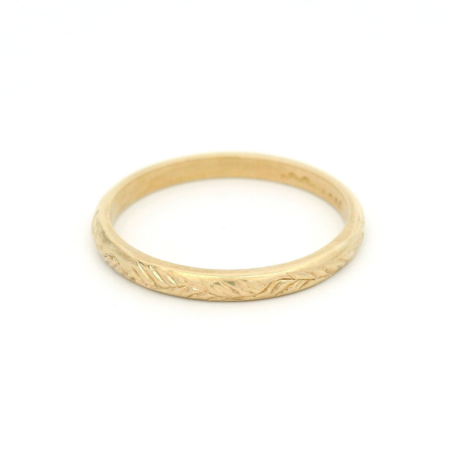 10K yellow gold 2mm soft dome profile band with hand-engraved vine pattern and detailed textured finish.