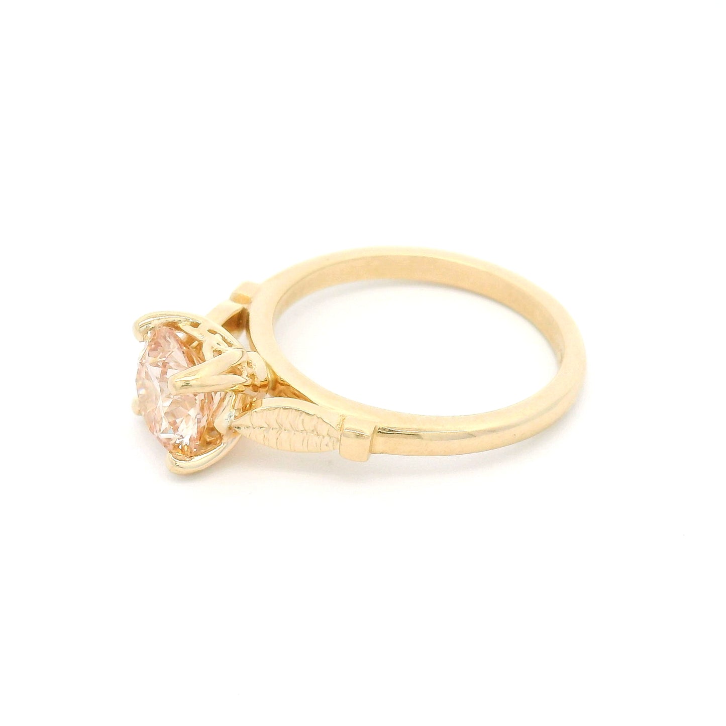 14K yellow gold solitaire engagement ring featuring a claw-set 1.50ct lab-grown light pink Fancy Pink diamond with hand-engraved leaf details on each side.