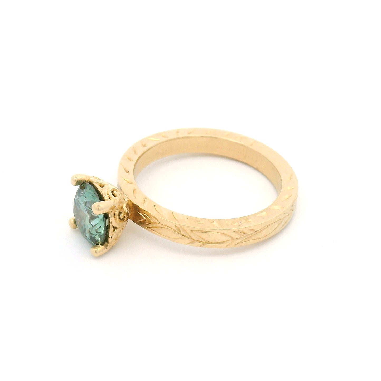 14K yellow gold solitaire engagement ring with 1.3ct lab-grown round brilliant Fancy Green diamond and hand-engraved vine and leaf pattern band.
