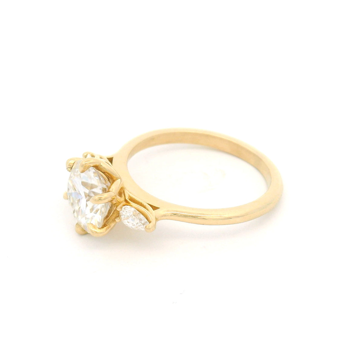 14K yellow gold three-stone engagement ring with a 1.77ct round moissanite and two pear lab-grown diamonds totalling 0.20cts.