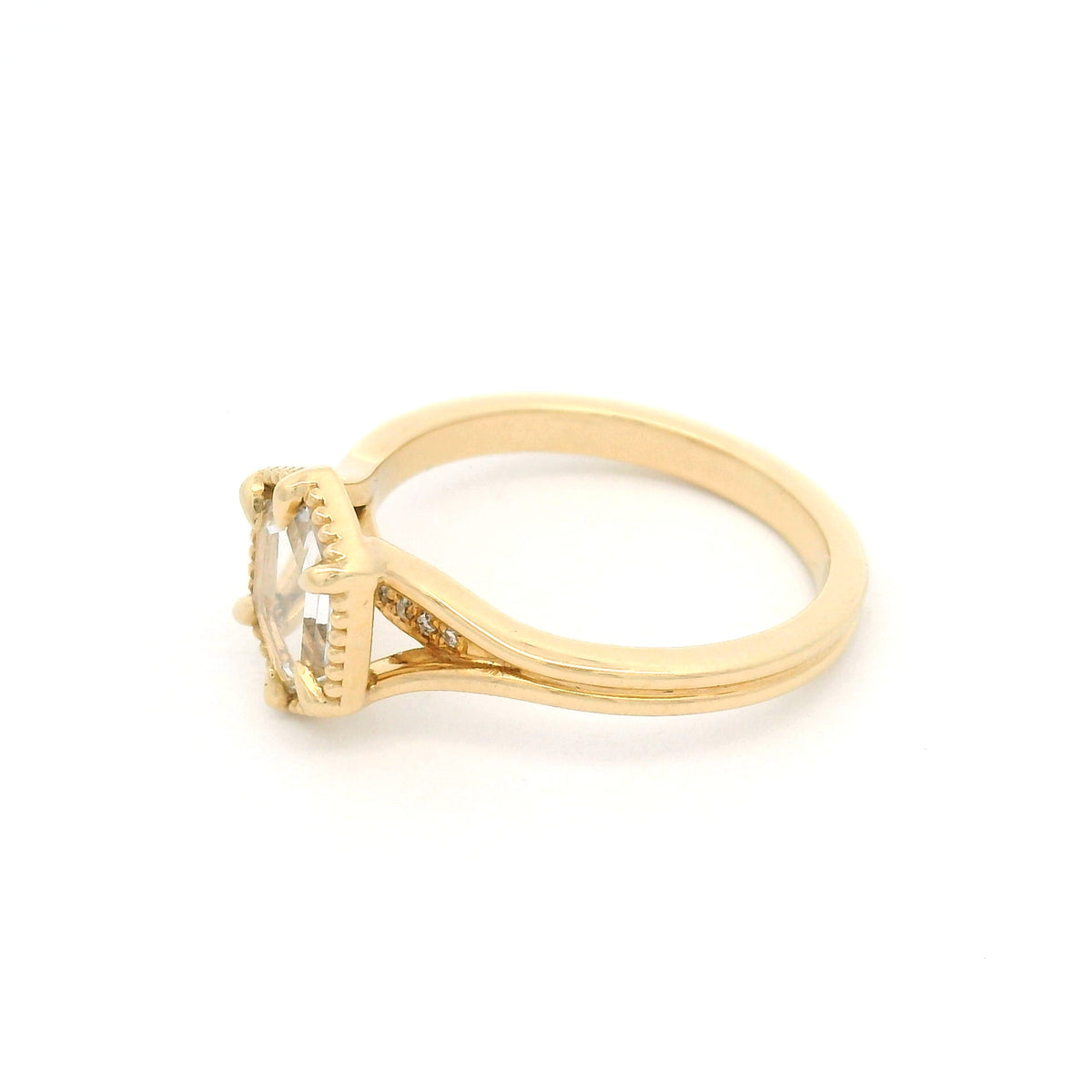 14K yellow gold engagement ring with a 0.82ct lab-grown step-cut hexagon white sapphire, claw setting, milgrain border and hidden diamond accents.