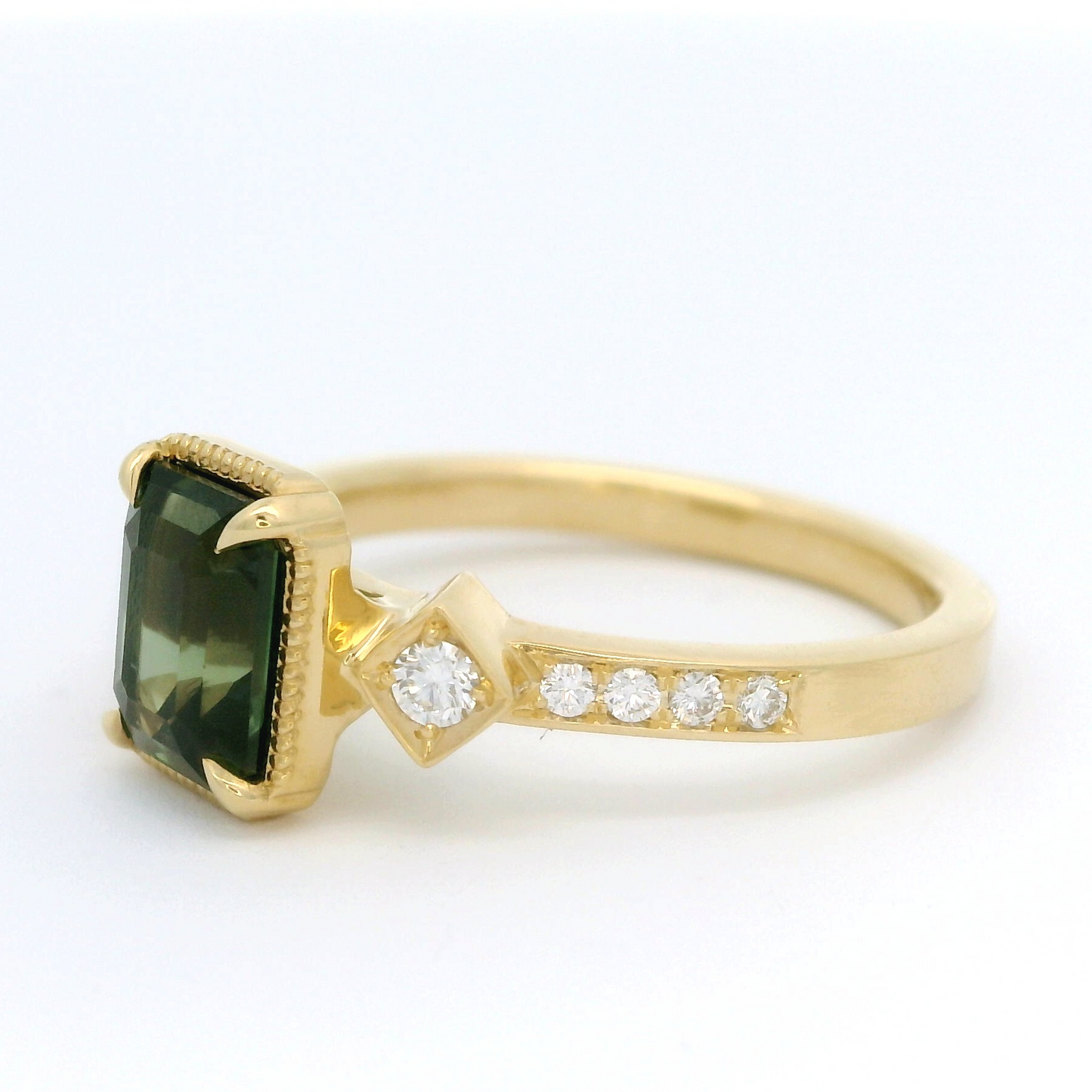 18k yellow gold ring with 1.55ct teal sapphire and accent diamonds. Shown from a angle.