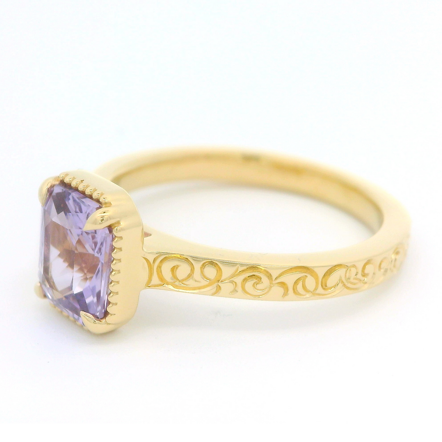 18k yellow gold ring with 1.63ct lavender sapphire and hand engraving. Shown from a jaunty angle.