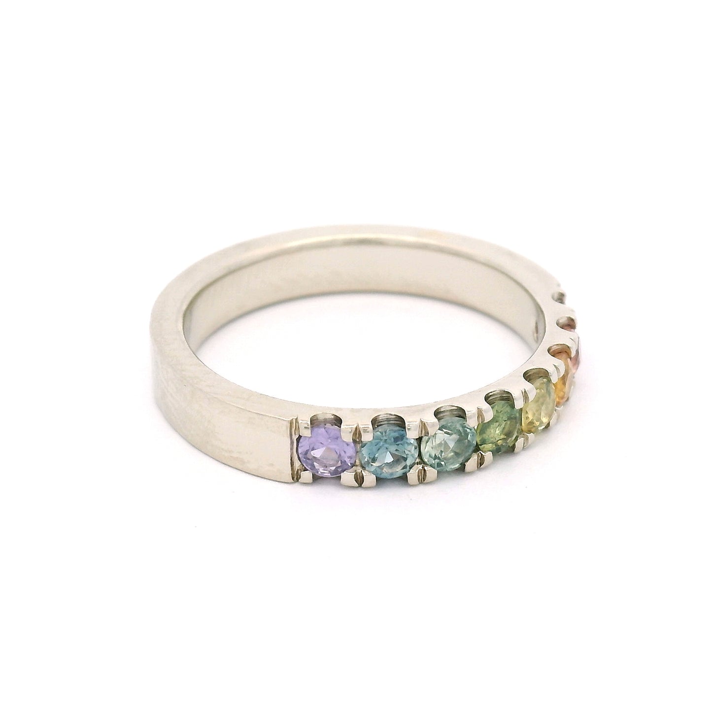 14K white gold rainbow band by Aimee Kennedy with eight 2.8mm round bead-set sapphires in rainbow colours and cut-through scalloped sides.