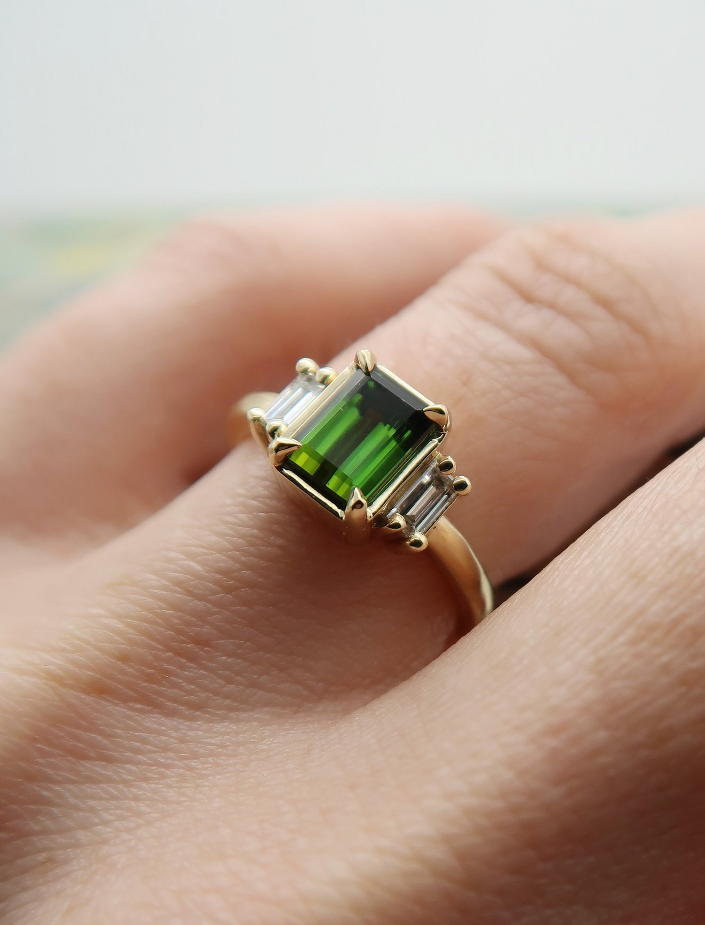 10k Yellow Green Tourmaline Ring with Baguette Diamond Accents. Worn on a finger.