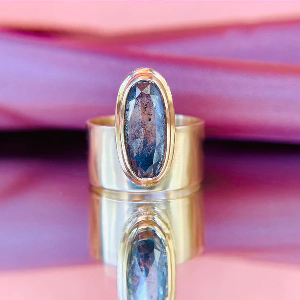 14k yellow gold ring set with a 3.18ct salt and pepper elongated oval rose cut diamond and hidden pave diamonds.