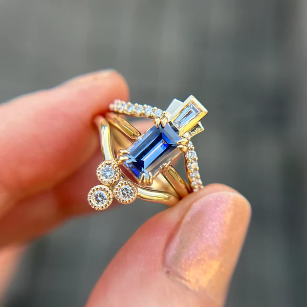 14k Yellow Contoured Band with a Colourless Diamond Trio. Shown stacked with an engagement ring and a second contrasting contoured band.