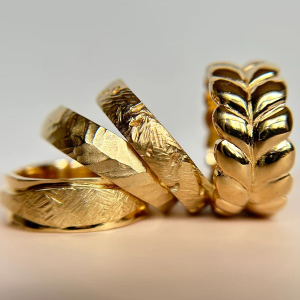 14k Yellow Gold Band Hand Carved with Matte Finish. Displayed with 3 other carved bands.