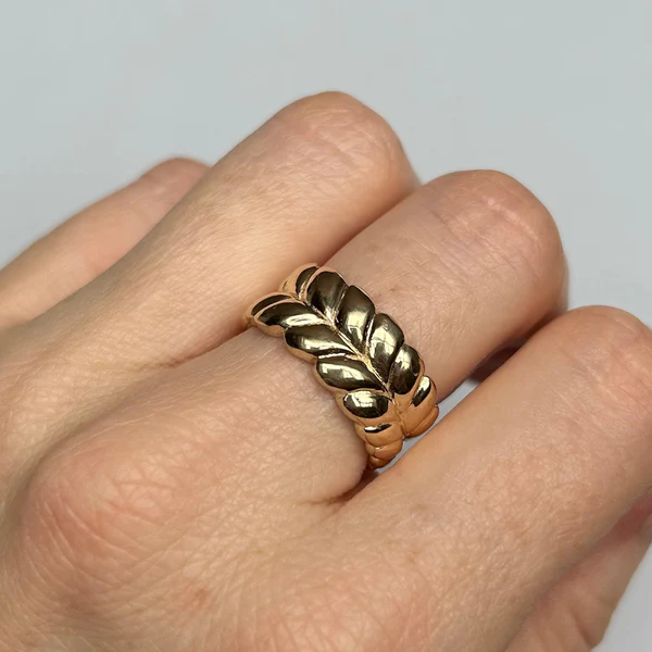 14k Yellow Gold Band Hand Carved with Braided Design. Displayed on a finger.