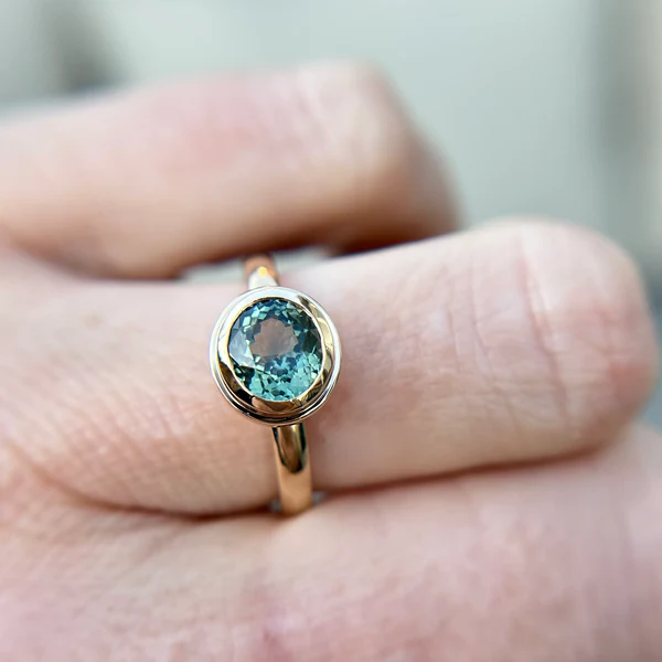 14k Yellow gold sapphire teal oval engagement ring Canadian. Worn on hand.