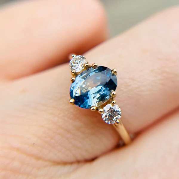 14k Yellow Ring with Bi-Colour Blue Sapphire Accented with Diamonds. Worn on hand.