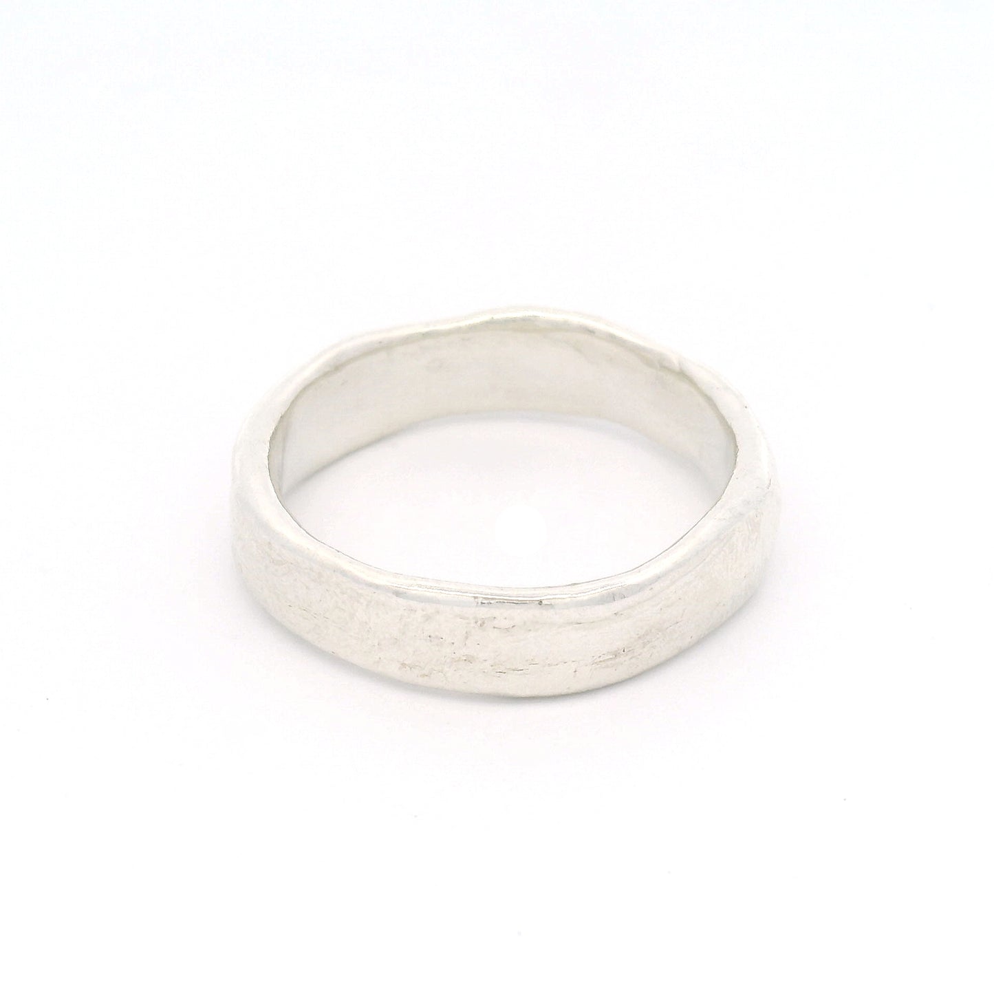 Sterling silver 5.5mm wedding band featuring a soft organic texture, gently domed profile, and comfort-fit interior.