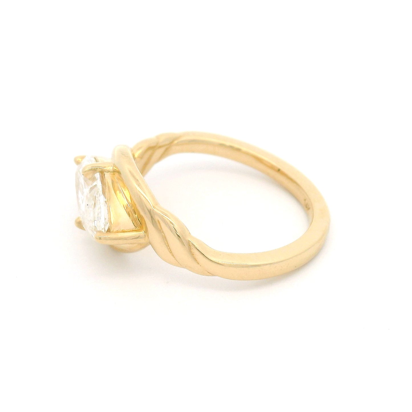 14K yellow gold low-profile solitaire engagement ring featuring a claw-set 1.40ct marquise-cut lab-grown diamond with VVS2 clarity, D colour, and ribbon-like setting details.