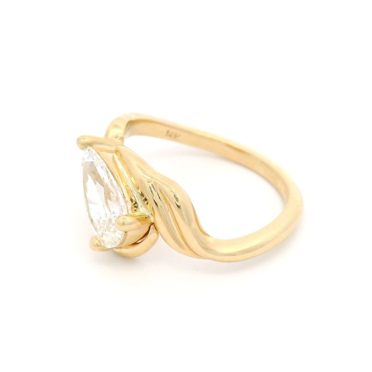 14K yellow gold low-profile solitaire engagement ring with a claw-set 1.25ct pear-shaped lab-grown diamond and sculptural ribbon-like setting.