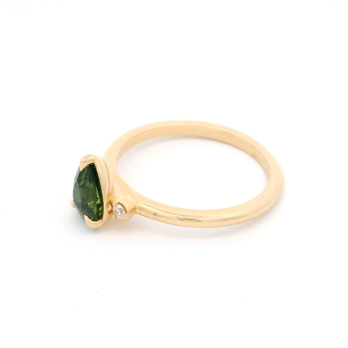 14K yellow gold claw-set three-stone ring with a 1.09ct pear-cut Madagascar green sapphire and two round lab-grown diamond accents.