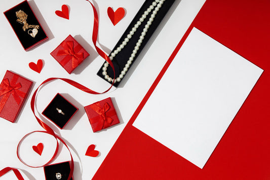 Top view of different types of jewellery in red gift boxes with bows