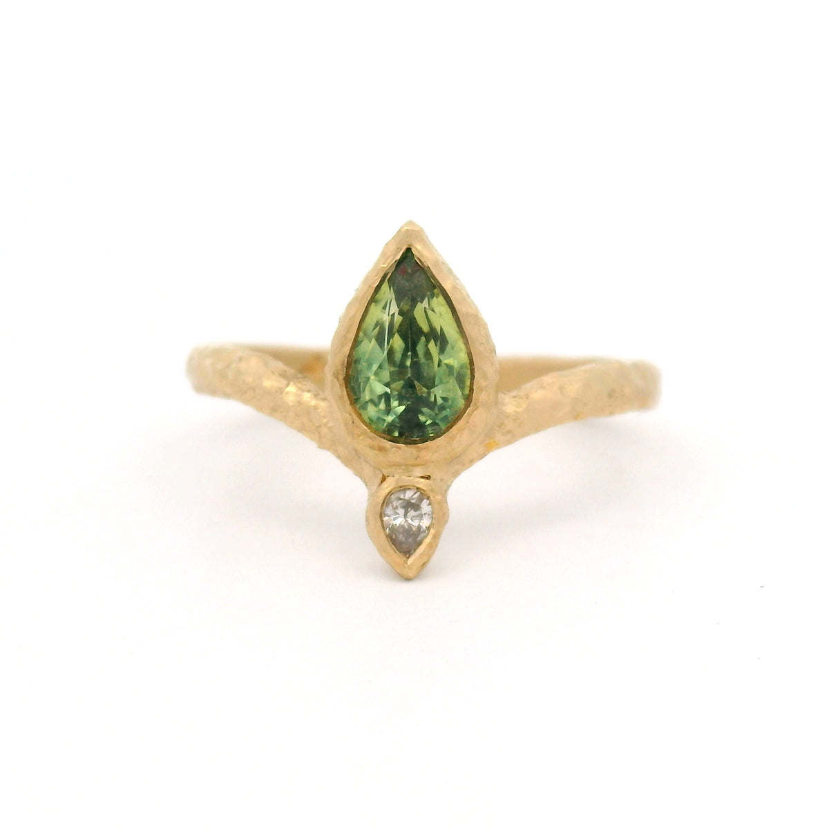 14K yellow gold Moi et Toi engagement ring with bezel-set pear-shaped green sapphire and diamond pointing outward on an organic textured diadem band.