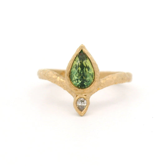 14K yellow gold Moi et Toi engagement ring with bezel-set pear-shaped green sapphire and diamond pointing outward on an organic textured diadem band.