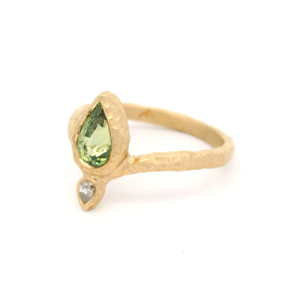 14K yellow gold Moi et Toi engagement ring with bezel-set pear-shaped green sapphire and diamond pointing outward on an organic textured diadem band.