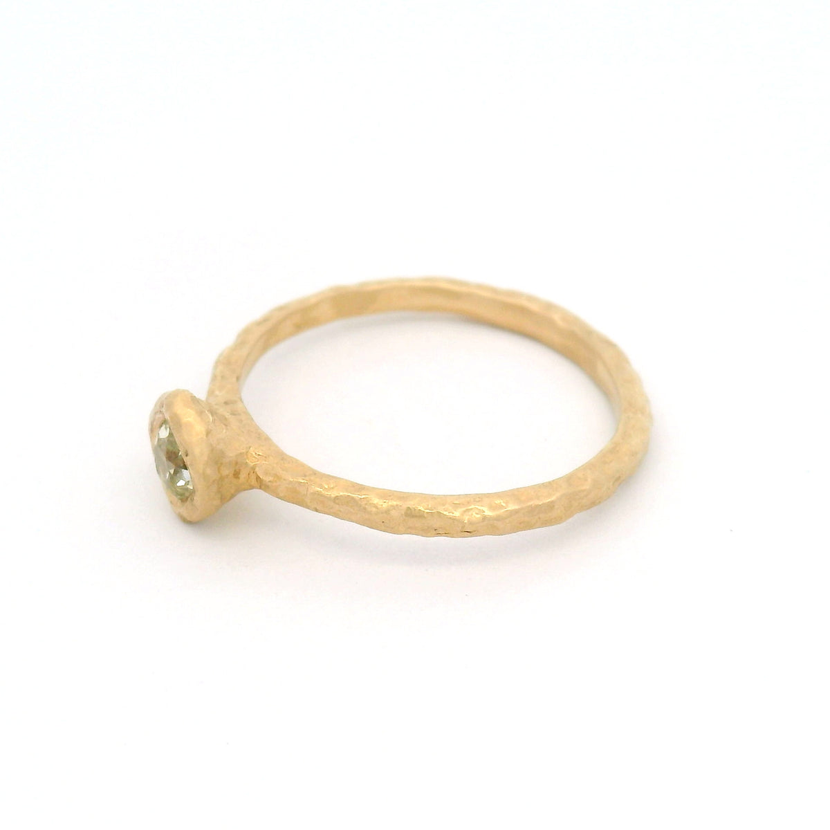 14K yellow gold organic-textured solitaire ring with a bezel-set natural 0.28ct Old European-cut diamond in a slim gold band.