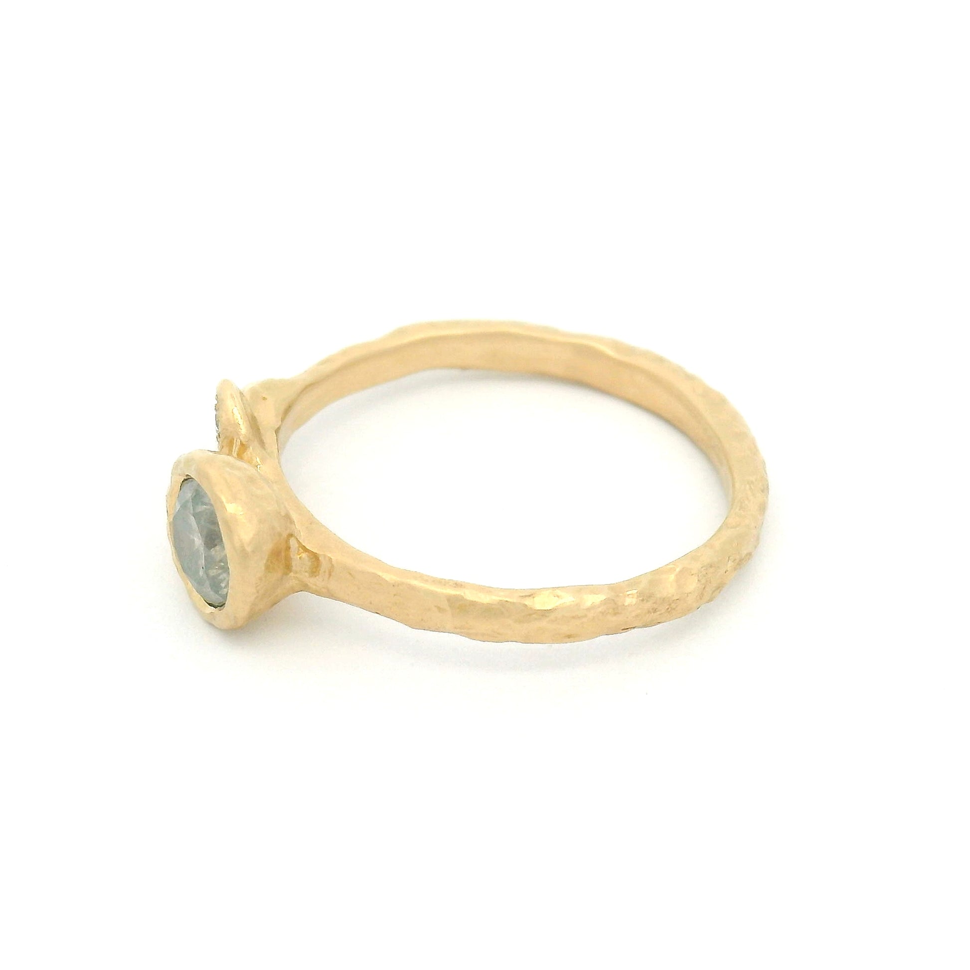 14K yellow gold organic engagement ring featuring a bezel-set 0.51ct icy grey round brilliant diamond and three natural diamond accents set in sculpted leaves.