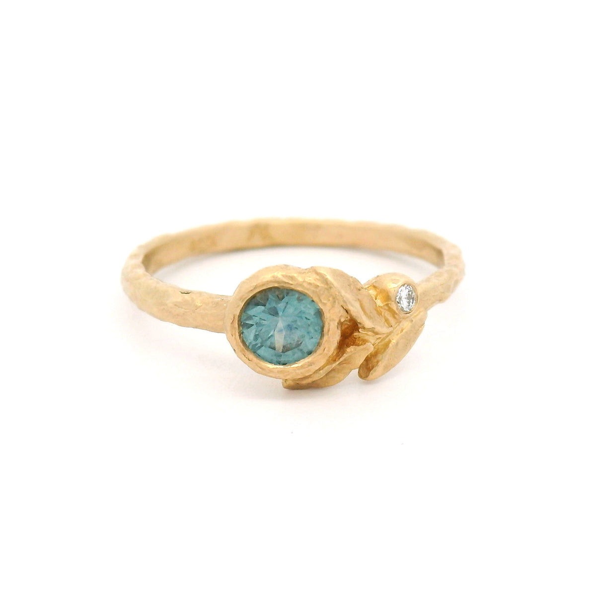 14K yellow gold textured asymmetric engagement ring with a 0.41ct round light-blue sapphire and a diamond accent nestled among three sculpted leaves.