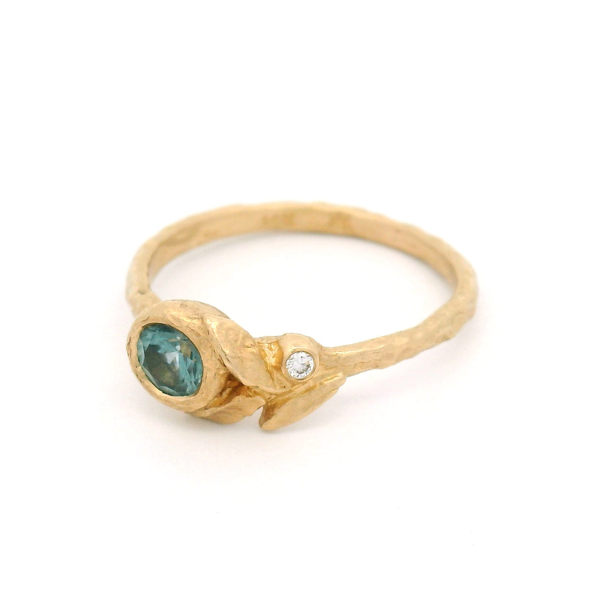 14K yellow gold textured asymmetric engagement ring with a 0.41ct round light-blue sapphire and a diamond accent nestled among three sculpted leaves.