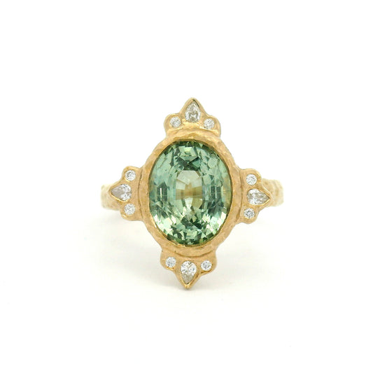 14K yellow gold organic engagement ring with a natural 4.2ct oval mint green sapphire, pear and round diamond accents, and a textured bezel-set design.