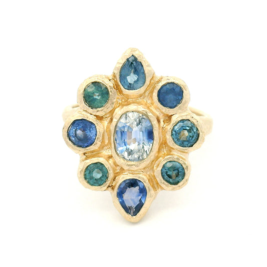 14K yellow gold organic cluster engagement ring with natural 0.66ct oval blue sapphire and 1.72cts pear-shaped and round blue sapphire accents.