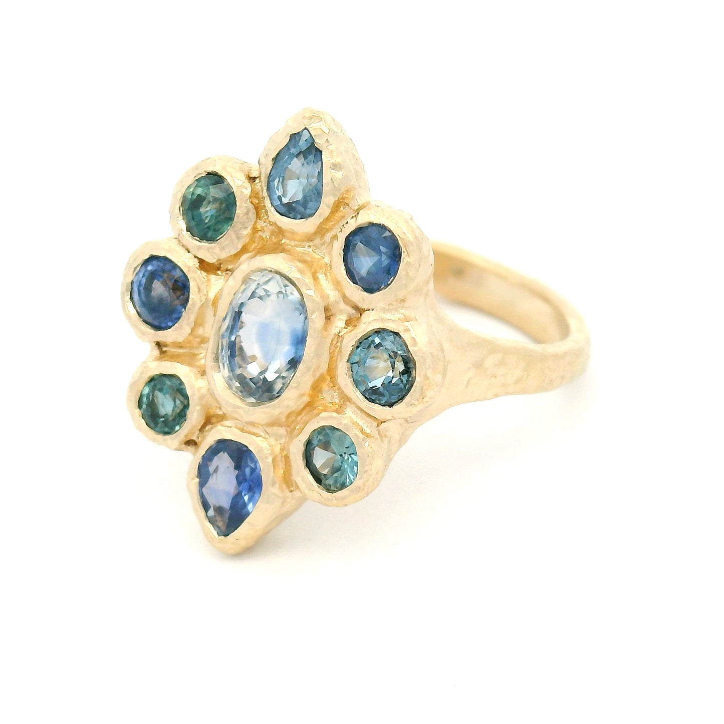 14K yellow gold organic cluster engagement ring with natural 0.66ct oval blue sapphire and 1.72cts pear-shaped and round blue sapphire accents.