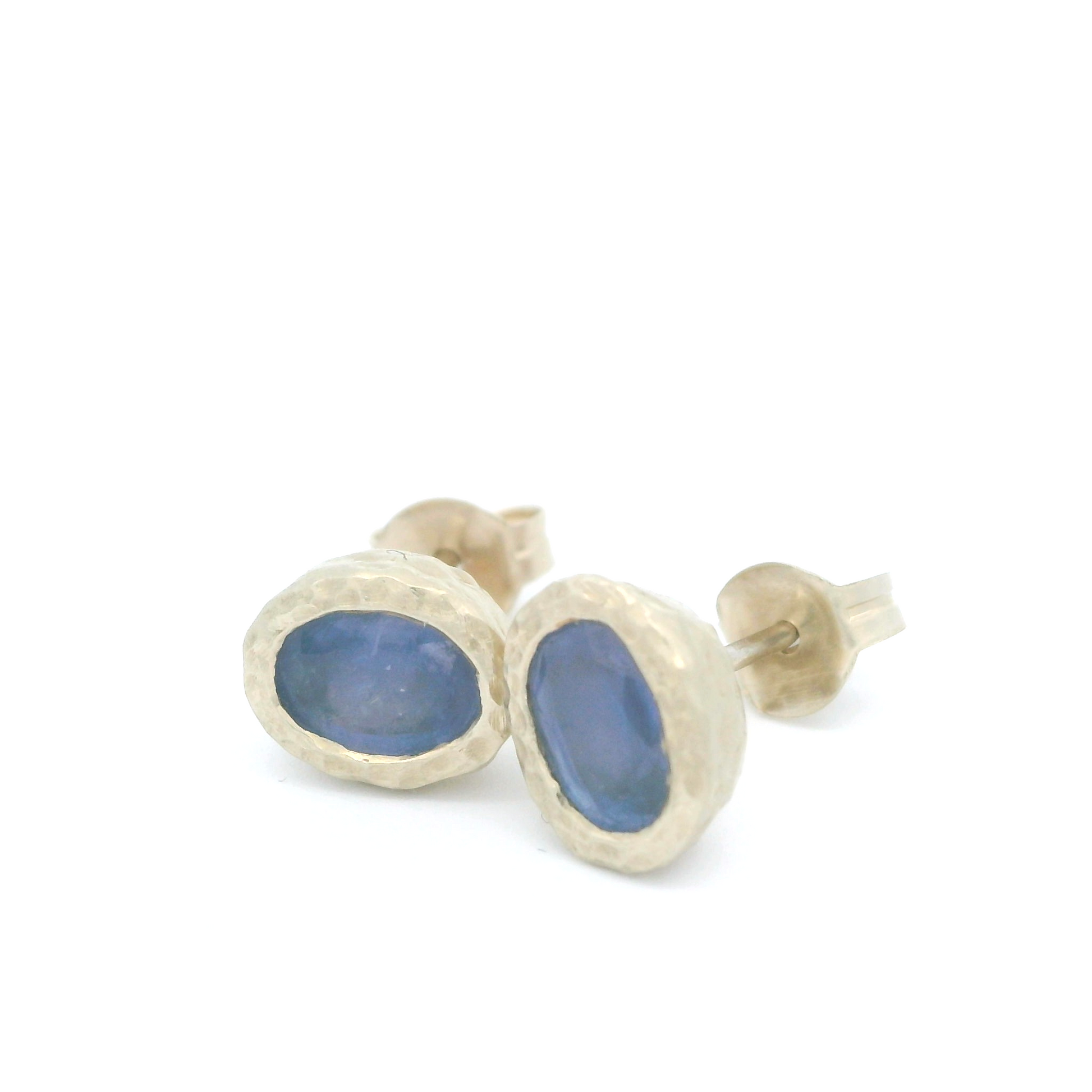 14k white textured organic stud earrings bezel set with oval blue sapphires. Another view.