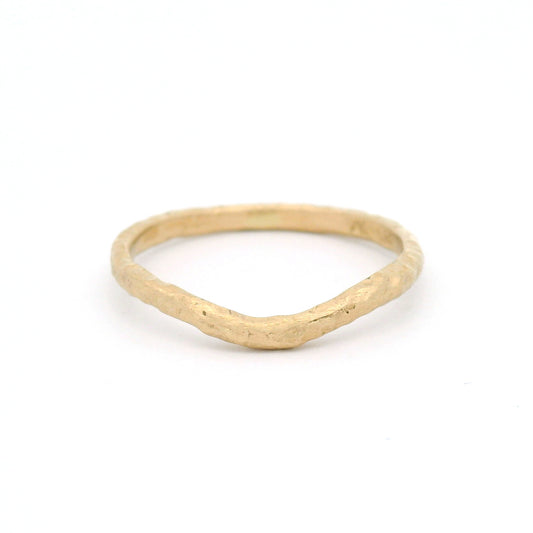 14K yellow gold 1.8mm contoured wedding band with an organic textured surface inspired by weathered sand and gentle waves.