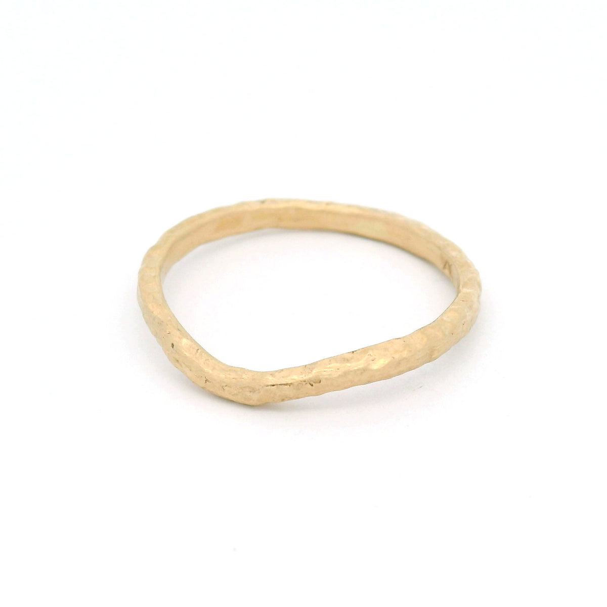 14K yellow gold 1.8mm contoured wedding band with an organic textured surface inspired by weathered sand and gentle waves.