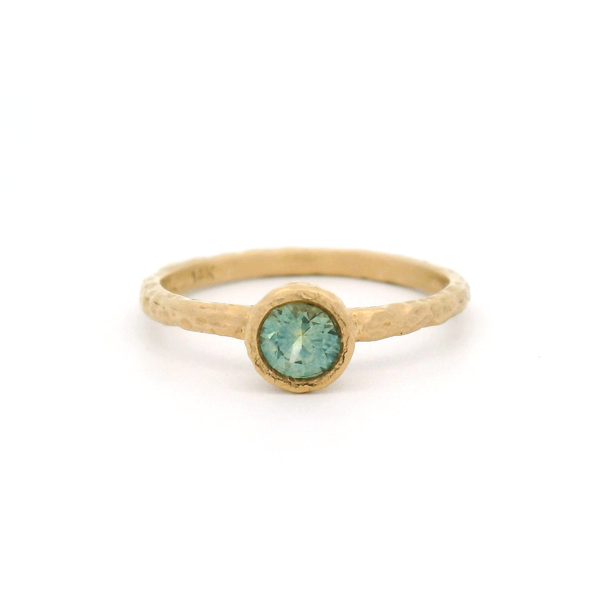 14K yellow gold organic hammered solitaire ring featuring a bezel-set 0.44ct round teal sapphire.