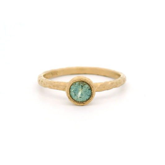 14K yellow gold organic hammered solitaire ring featuring a bezel-set 0.44ct round teal sapphire.