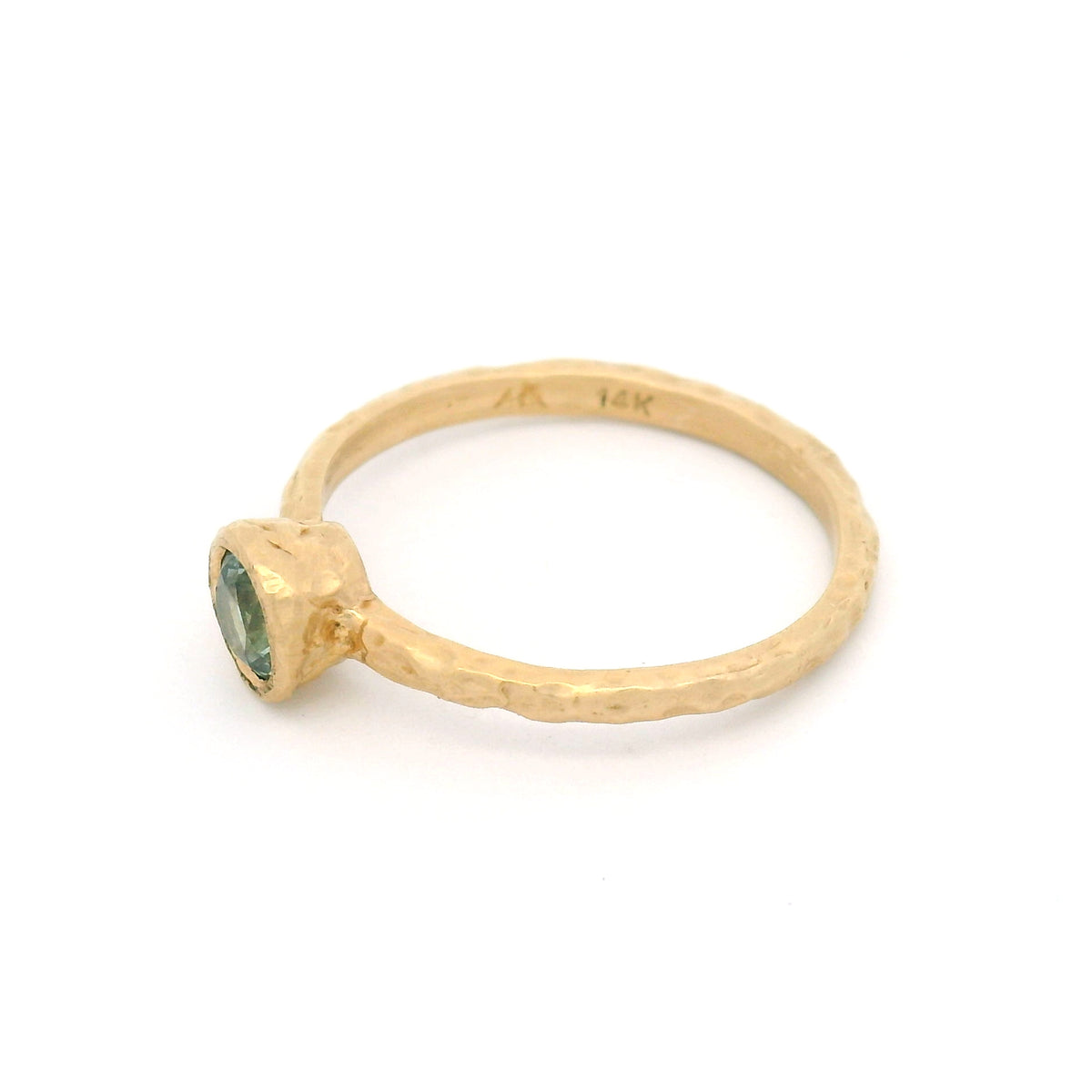 14K yellow gold organic hammered solitaire ring featuring a bezel-set 0.44ct round teal sapphire.