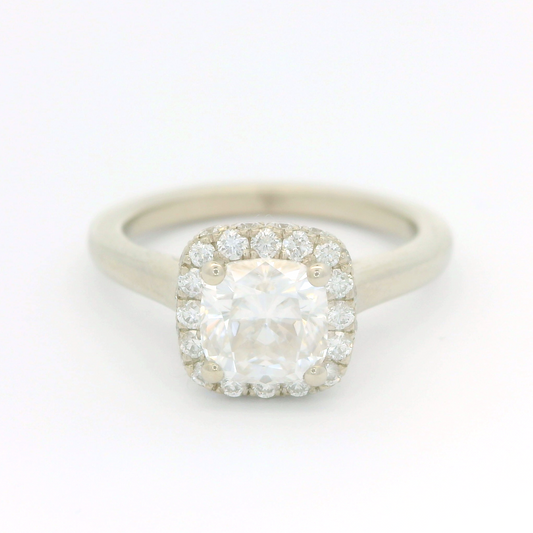 14k white ring set with a 1.1ct moissanite and a accent double sided diamond halo.