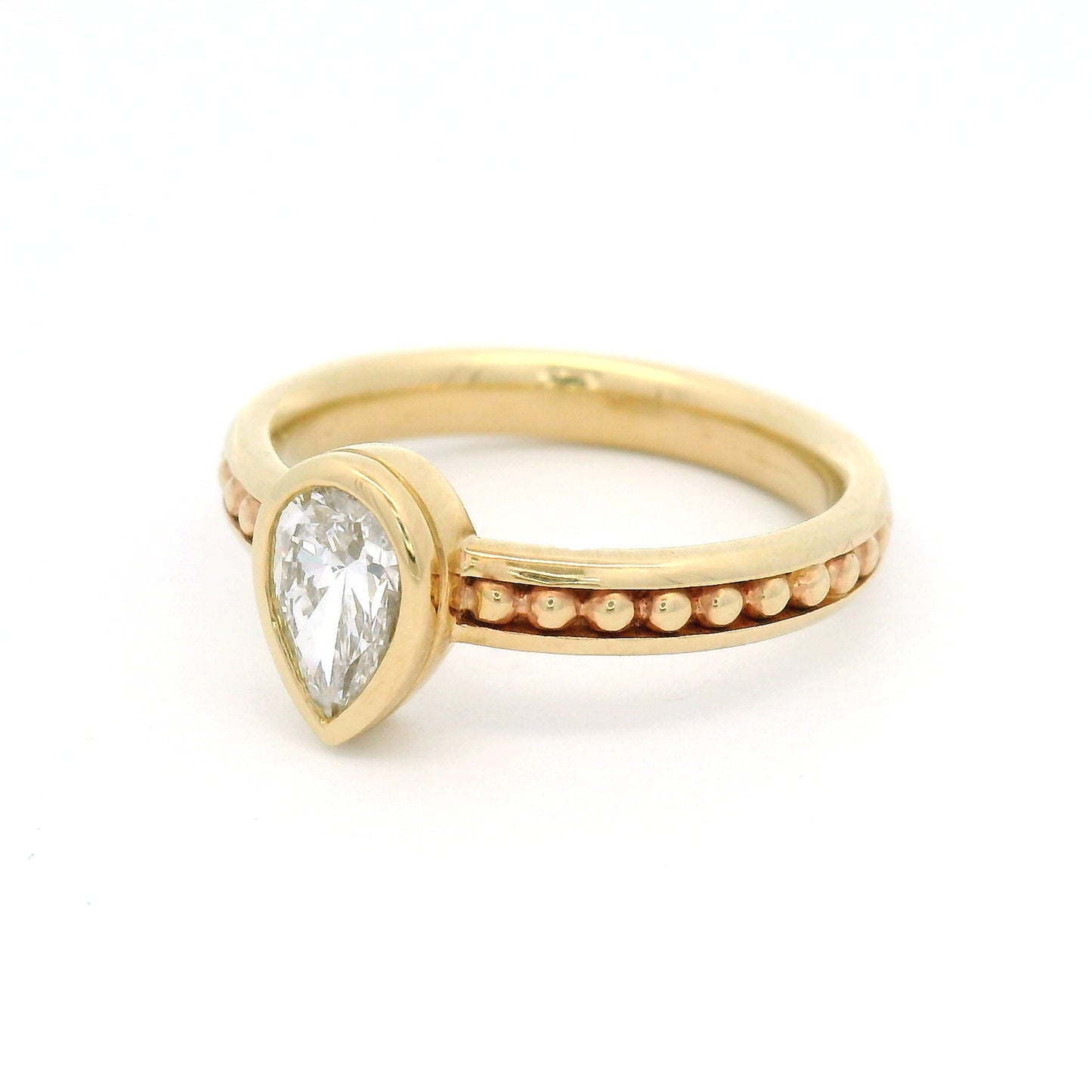 10K yellow gold solitaire engagement ring with a 0.54ct lab-grown pear-shaped diamond, delicate gold bead accents, and channel-set detailing along the band.