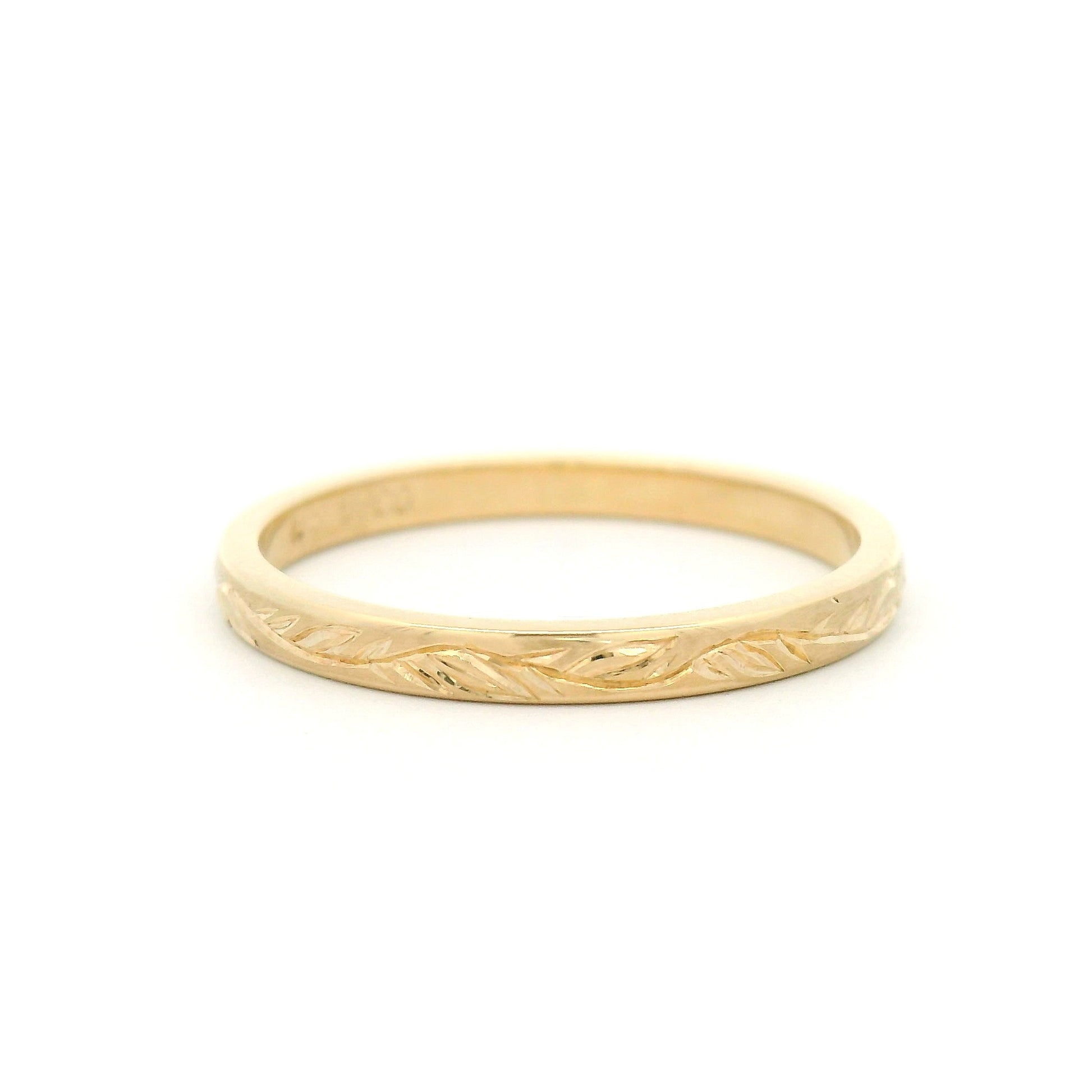 10K yellow gold 2mm flat profile band with hand-engraved vine pattern and detailed nature-inspired design.