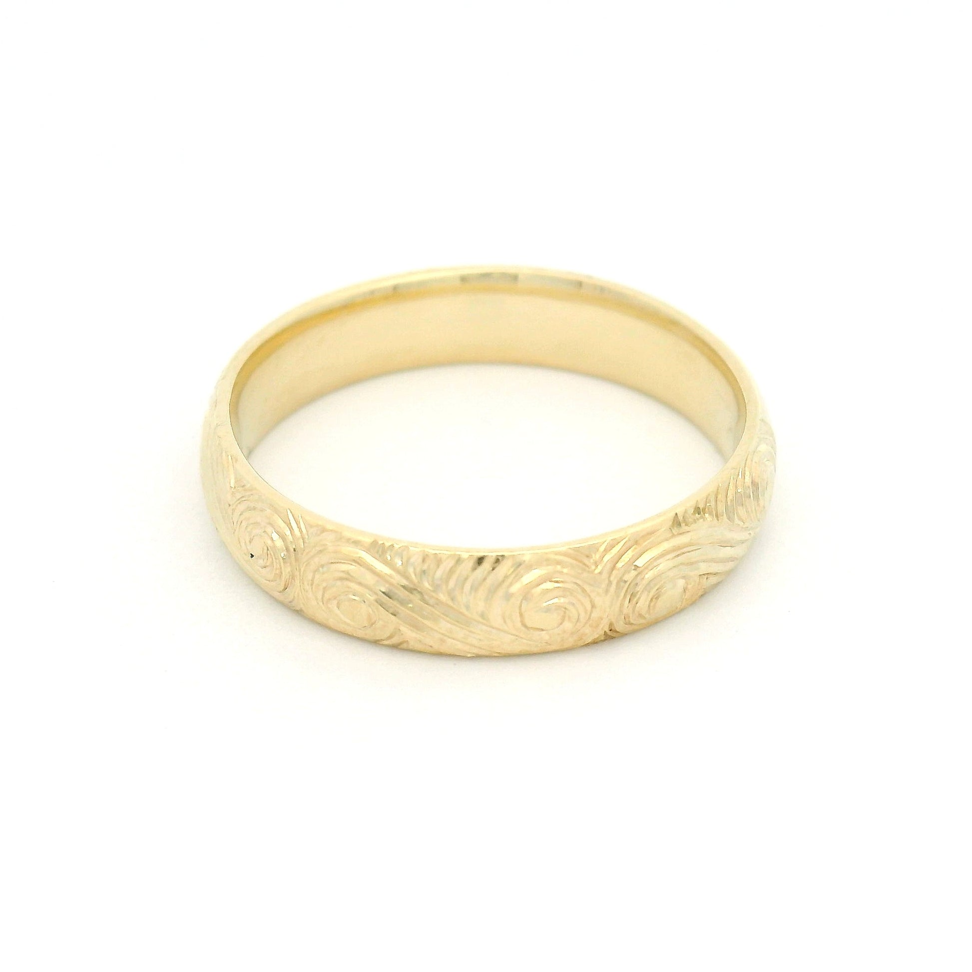 10K yellow gold 4mm soft domed band with hand-engraved ocean wave pattern and textured finish.
