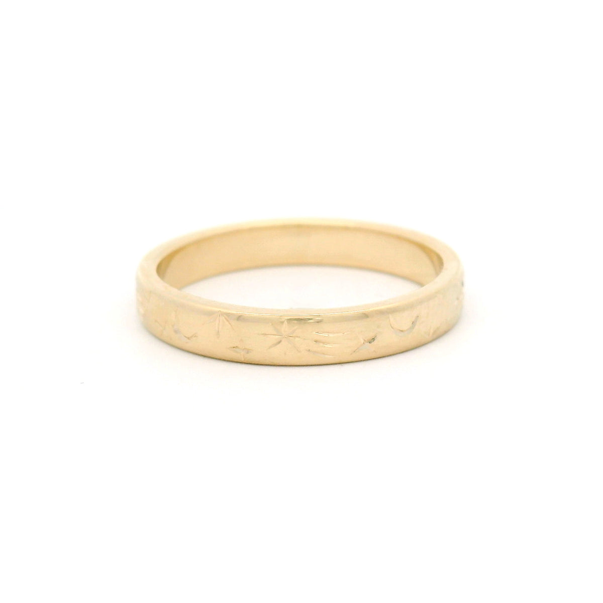 14K yellow gold 3mm flat band featuring intricate hand-engraved celestial star and moon motifs flowing across half the ring.