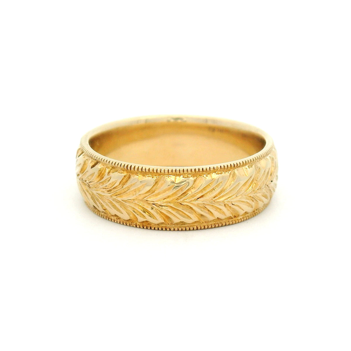 14K yellow gold 6mm wedding band featuring a hand-engraved leaf pattern and fine milgrain edges with vintage-inspired detailing.