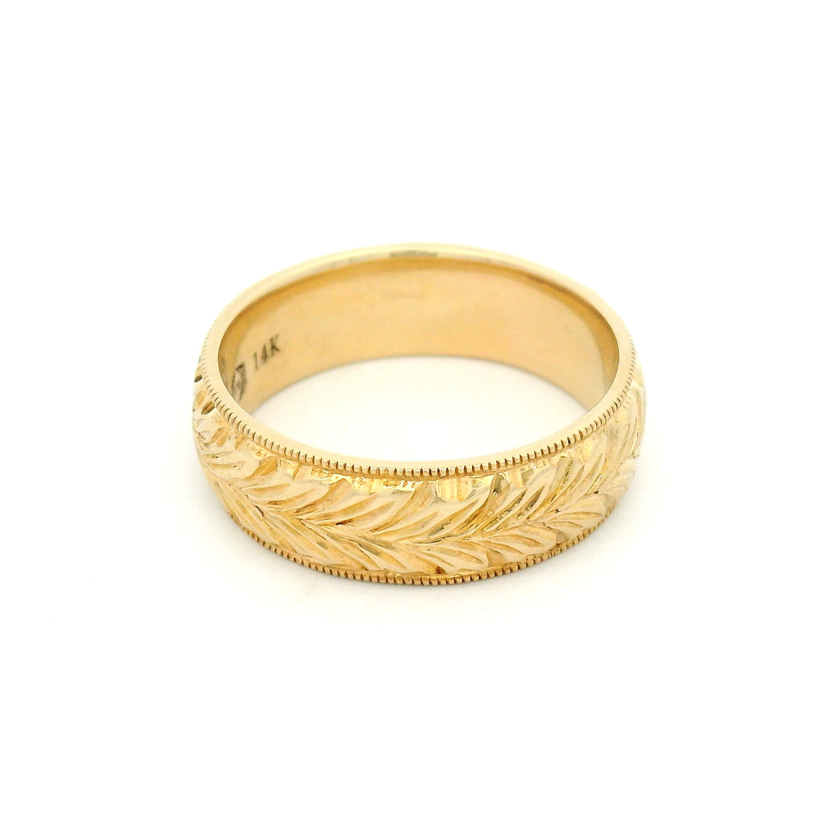 14K yellow gold 6mm wedding band featuring a hand-engraved leaf pattern and fine milgrain edges with vintage-inspired detailing.