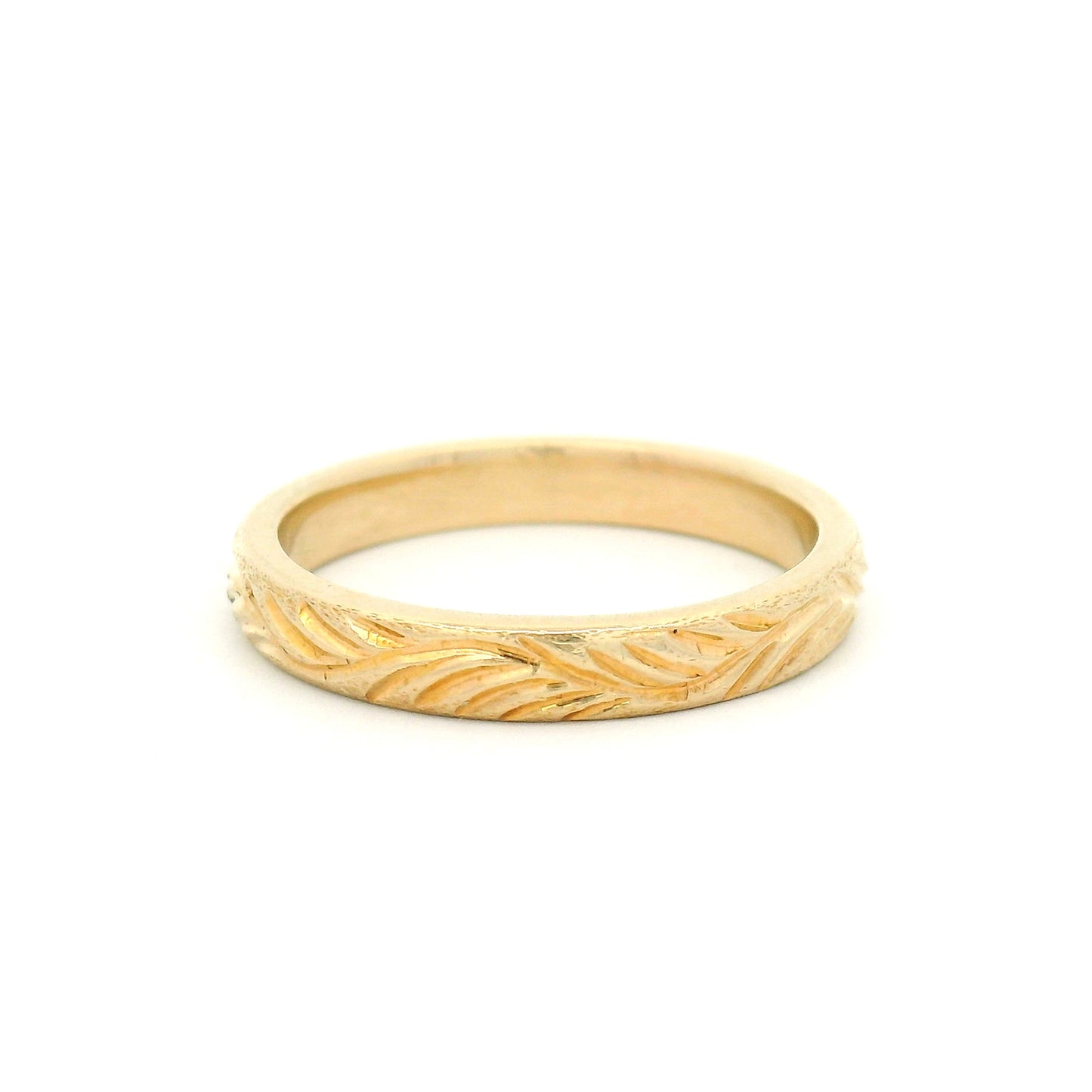 14K yellow gold 3mm soft domed wedding band featuring a hand-engraved leafy branch design with nature-inspired detailing.