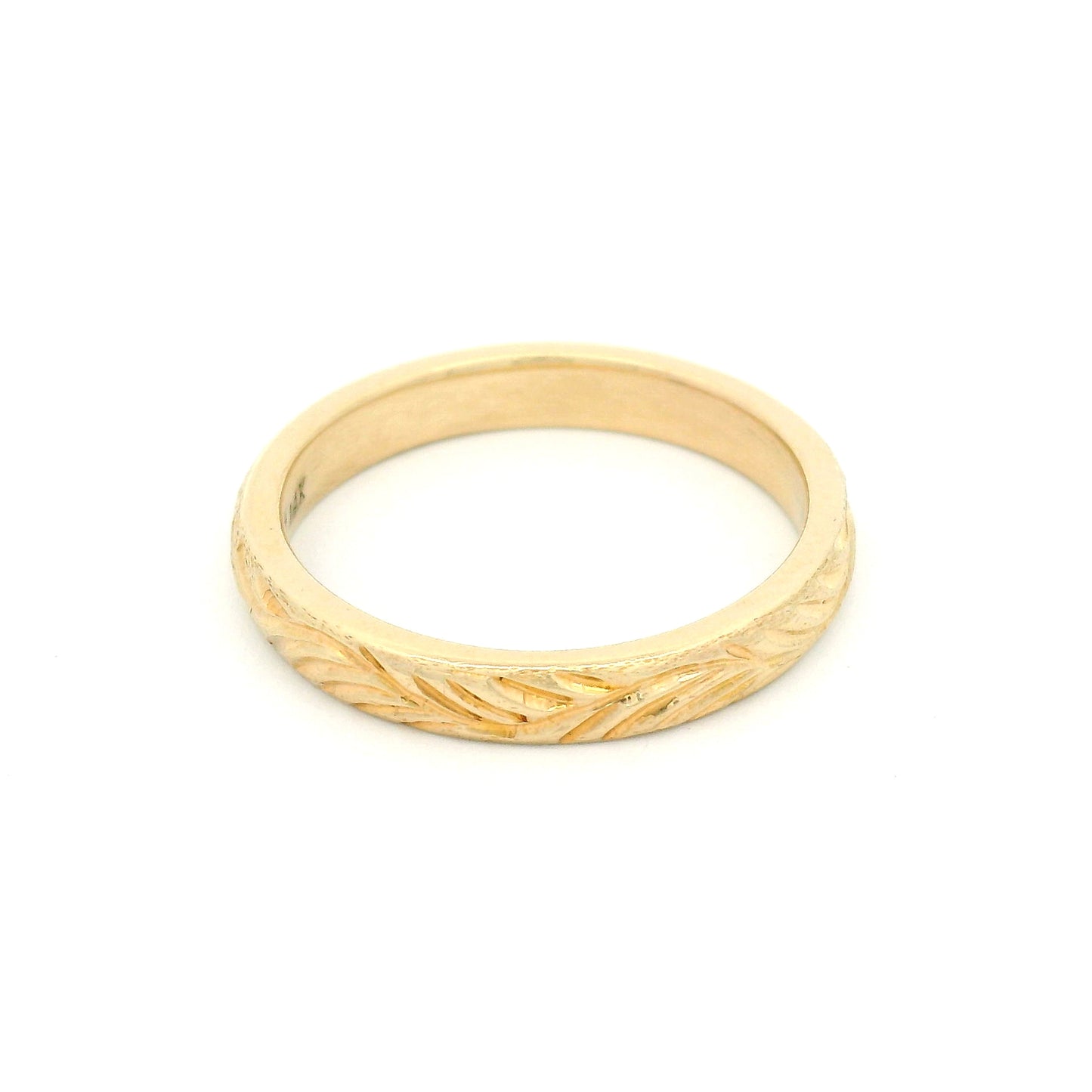 14K yellow gold 3mm soft domed wedding band featuring a hand-engraved leafy branch design with nature-inspired detailing.
