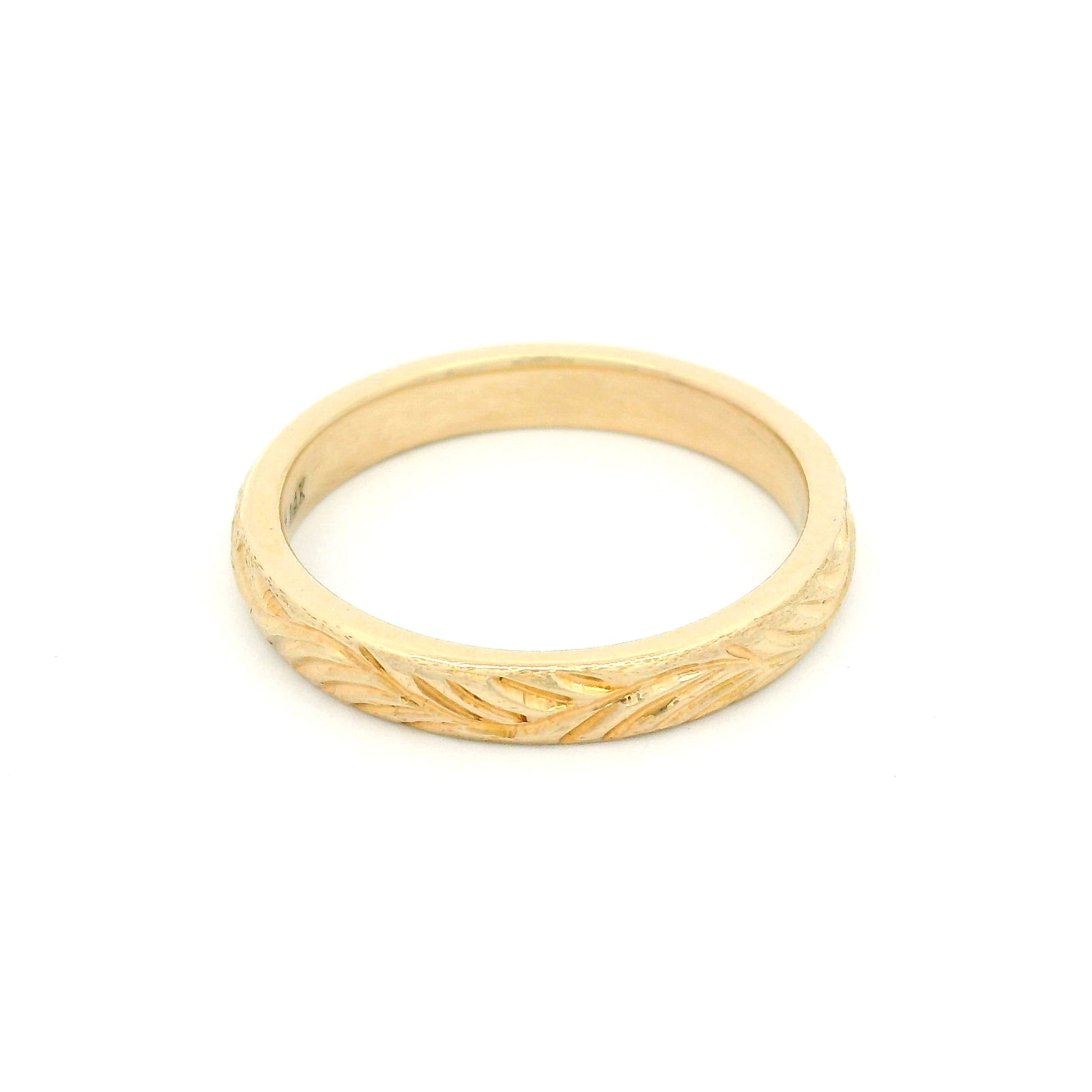 14K yellow gold 3mm soft domed wedding band featuring a hand-engraved leafy branch design with nature-inspired detailing.