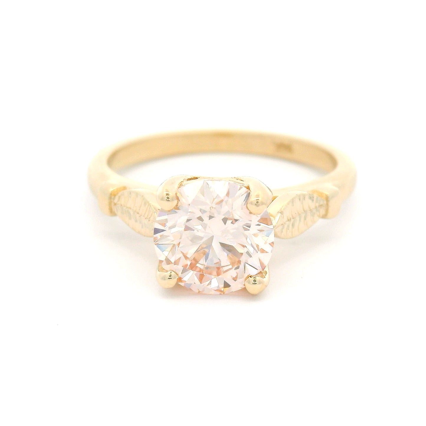 14K yellow gold solitaire engagement ring featuring a claw-set 1.50ct lab-grown light pink Fancy Pink diamond with hand-engraved leaf details on each side.