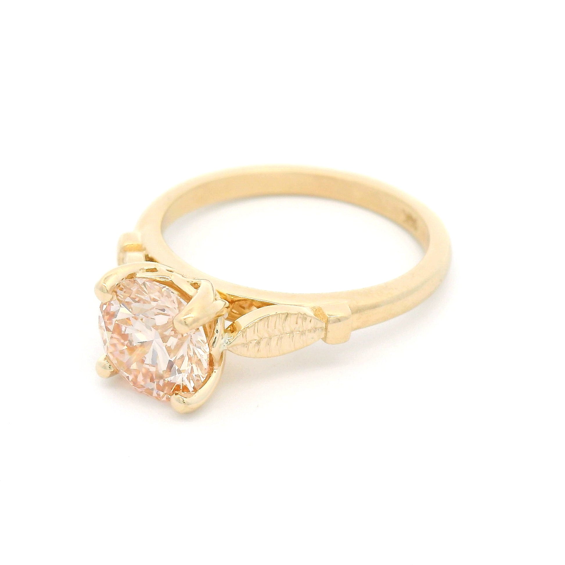 14K yellow gold solitaire engagement ring featuring a claw-set 1.50ct lab-grown light pink Fancy Pink diamond with hand-engraved leaf details on each side.