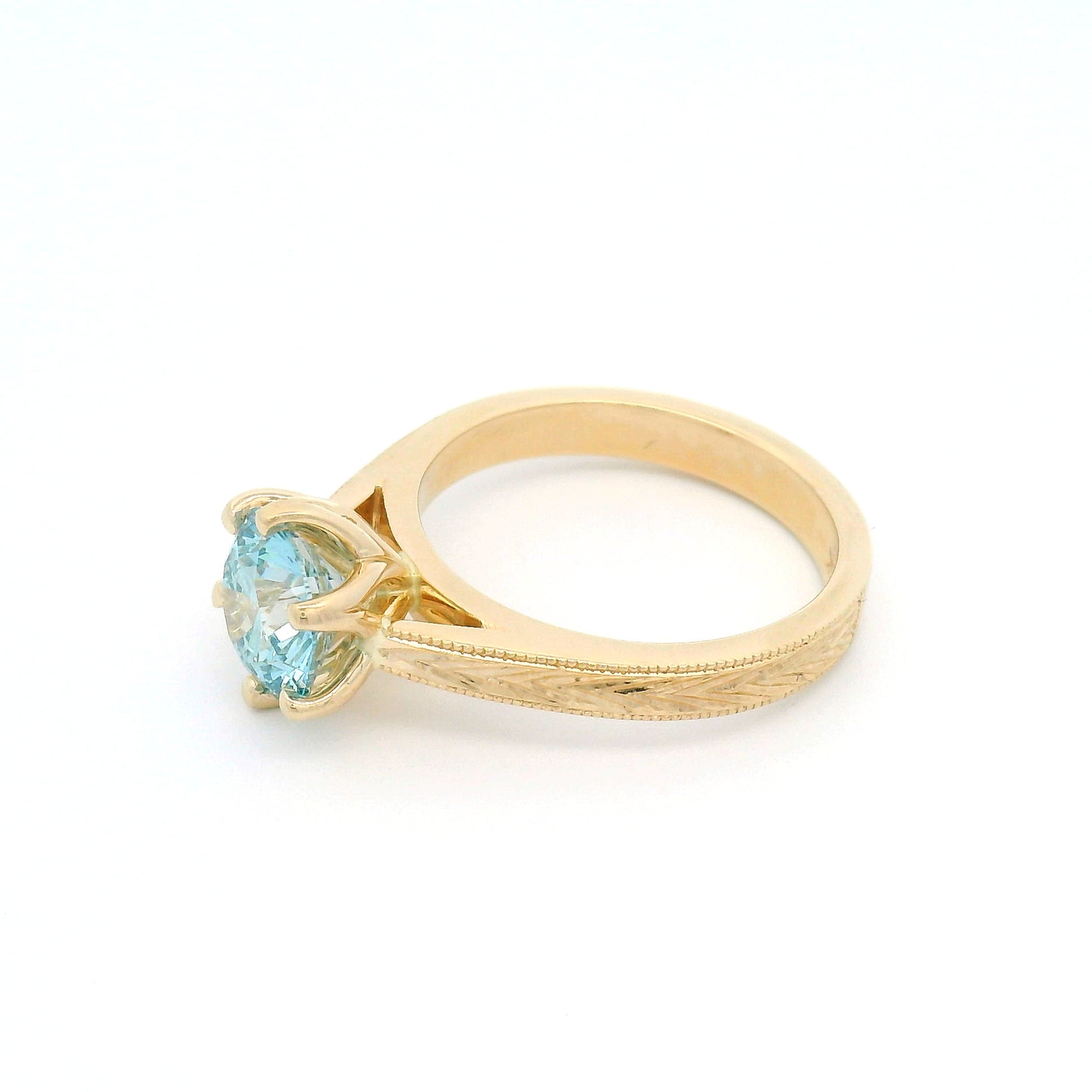 14K yellow gold solitaire engagement ring featuring a claw-set 1.63ct lab-grown round brilliant-cut Fancy Intense Blue-Green diamond with hand-engraved wheat patterns on each side.